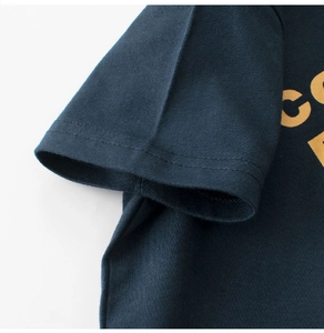 Gros plan détaillé sur la manche d'un t-shirt en coton bleu marine et son imprimé
