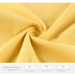 Close-up of soft yellow cotton fabric texture and safety certification label for kids T-shirt