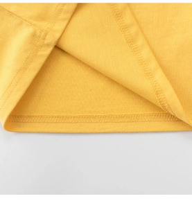 Detail of double-needle stitching on the hem of a mustard yellow cotton t-shirt