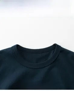 Dettaglio di t-shirt blu scuro con scollo a girocollo, doppia cucitura e stampa a lettere