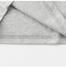 Détail de la double piqûre et de la couture surjetée sur l'ourlet d'un t-shirt gris chiné