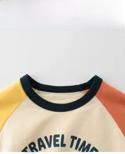 Detail of the blue ribbed neckline on a boys' color-block raglan tee with Travel Time print