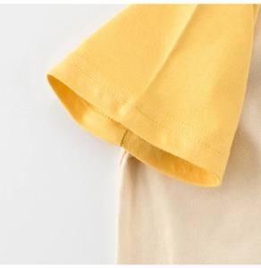 Close-up of raglan sleeves and stitching on a yellow and white cotton kids' T-shirt