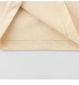 Detailed close-up of smooth stitching and hem texture on kids cotton T-shirt