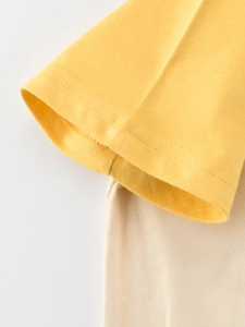 Close-up of yellow and beige cotton raglan sleeve cuff on a boy's summer t-shirt