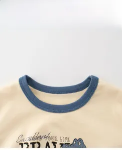 Detail view of cotton t-shirt neckline with blue ribbing and cartoon print