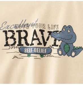Close-up of cotton kids T-shirt featuring a cartoon crocodile on a skateboard with text