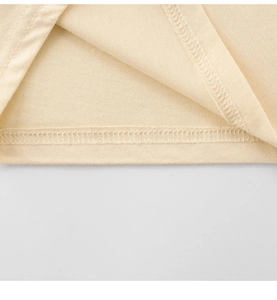 Detailed close-up showing the precise double-needle stitching on a beige cotton t-shirt hem