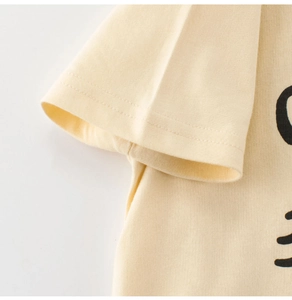 Detail of soft yellow cotton t-shirt sleeve with neat double-needle stitching and print