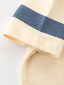Short sleeve cotton T-shirt featuring navy blue stripes on cream knit fabric cuffs