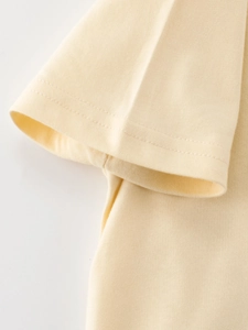 Light yellow cotton kids T-shirt featuring smooth stitching and durable double-needle cuffs