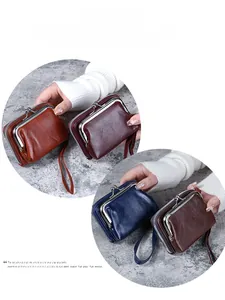 Detail of retro leather mini wallet with metal kiss-lock closure and wrist strap