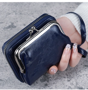 Detail showing deep blue coin purse with metal frame closure and wrist strap