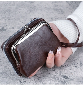 Detail of dark brown leather wallet showing vintage metal clasp and zipper closure with wristlet