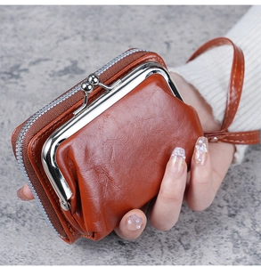 Detailed view of brown lychee grain leather wallet featuring metal clasp and wrist strap