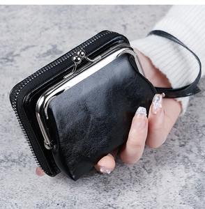 Detail of black matte leather wallet featuring vintage metal clasp and zipper pocket