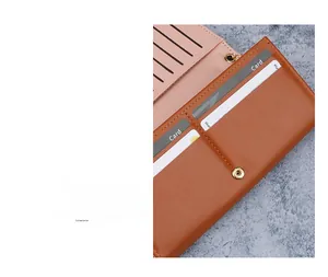 Close-up of brown leather long wallet featuring pink interior card slots and gold metal snap
