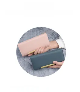 Detail of slim long wallets in pink and blue leather with elegant gold metal trim bar