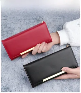 Close-up of long wallets in black and burgundy with gold metal bar details and leather texture