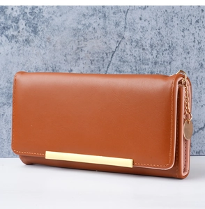 Detailed side view of brown leather long wallet with gold zipper and metal accent