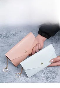 Detail of lychee textured leather wallets with gold snaps in pink and mint colors