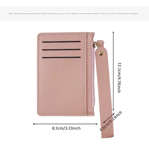 Detail view of pink slim card holder wallet with zipper pocket and wristlet strap