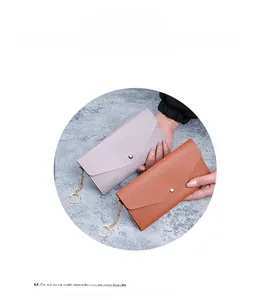 Close-up of lavender and brown envelope clutch wallets with pebbled faux leather texture
