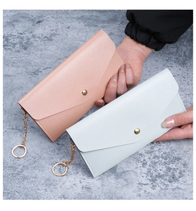 Detail of lychee pattern leather wallets in pink and blue with gold hardware snap