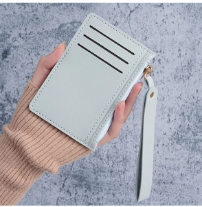Detail of slim PU leather card holder with three slots, zip pocket, and matching wrist strap