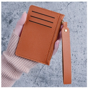 Detail of slim women's card holder in lychee texture leather with wrist strap and zipper