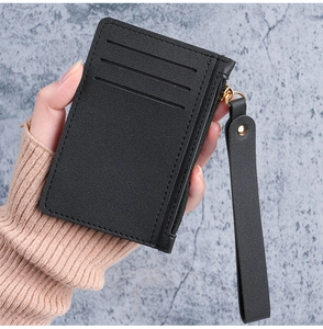 Macro detail of slim black card holder with leather texture and zip pocket