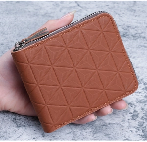 Détail du portefeuille en cuir marron avec motif géométrique 3D en relief et zip