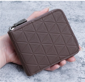 Détail macro du portefeuille marron pour homme avec gaufrage géométrique et zip