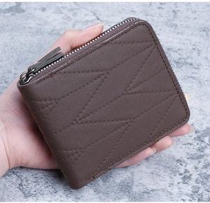 Detail of compact coffee brown quilted zipper wallet held by hand for size reference