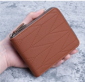 Close-up of brown leather short wallet with geometric stitching and silver zipper