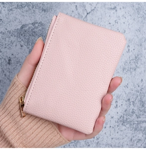 Close-up of pink litchi grain leather texture on small zip-around card wallet