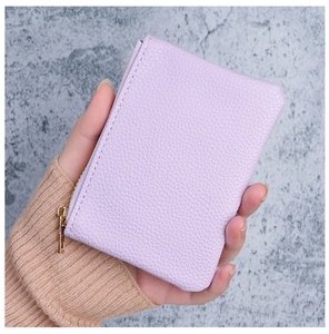 Close-up of light purple textured leather mini wallet with gold zipper detail