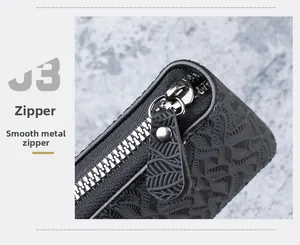 Close-up of smooth silver metal zipper on high-quality black embossed leather wallet