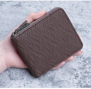 Close-up of dark brown men's wallet featuring embossed leaf texture and L-shaped zipper