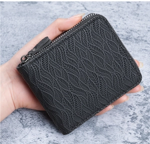 Close-up of black leather wallet with leaf vein embossed pattern and metal zipper detail