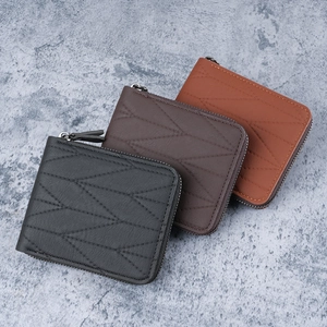 Three men's zip wallets in black and brown leather with quilted geometric patterns