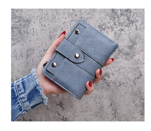 Detail showing the dark blue matte leather wallet with retro rivets and zipper closure