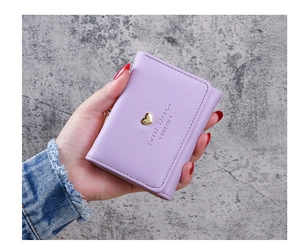 Detailed close-up of purple leather wallet featuring a gold heart buckle and embossed text