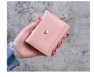Close-up of pink faux leather wallet featuring a gold heart and Sweet Dream engraving