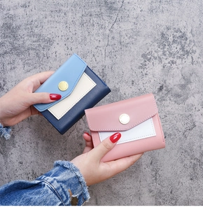Détail de portefeuilles enveloppe tricolores bleu et rose avec bouton gravé doré