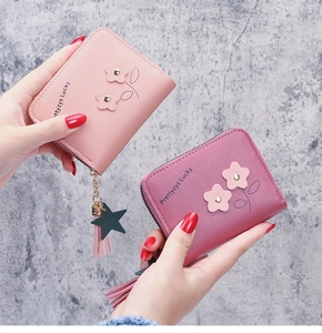 Detail view of small PU leather wallets with floral appliques and star tassel zippers