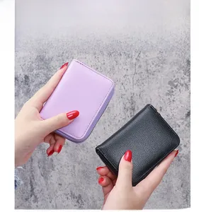 Litchi pattern leather wallet with metal zipper in purple and black held by a model