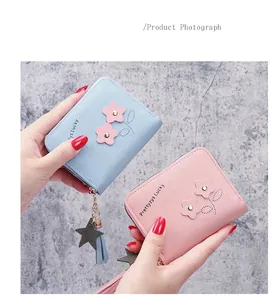 Dettaglio di piccoli portafogli in pelle PU con fiori carini e nappina a stella zip