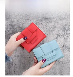 Detail of red and light blue small PU leather tri-fold wallets with secure flip-top buckle