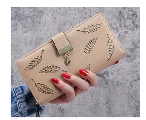 Close-up of beige leaf hollow pattern and metal leaf zipper puller on long wallet